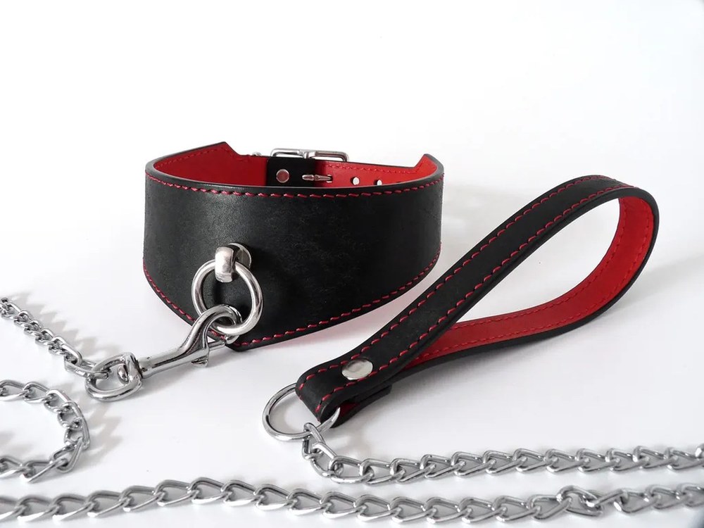 Laisse BDSM en cuir noir surpiqûres rouges avec collier et chaîne, style Dorcel